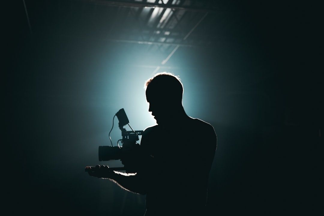 Silhouette einer filmenden Person mit Kamera im Gegenlicht