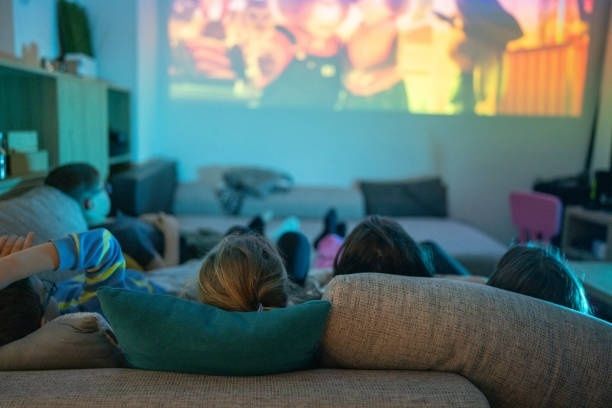Familie sitzt gemeinsam auf dem Sofa und schaut einen Film